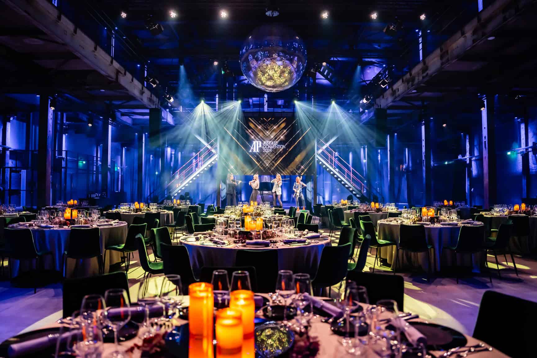 Interieur van de Middenfabriek met sfeervolle verlichting en feesttafels voor een evenement.