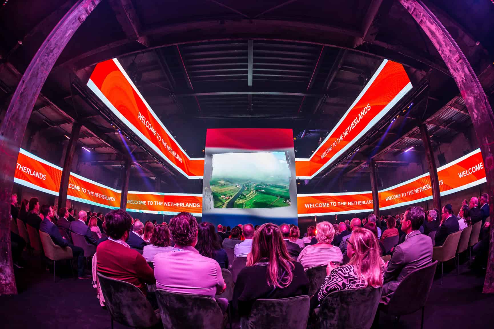 Grootschalige presentatie in de Middenfabriek met publiek en grote schermen.