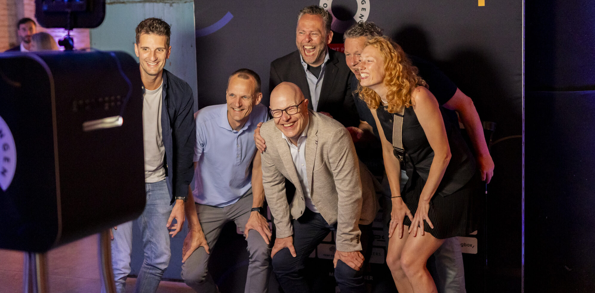 Uitzicht op de stad bij schemering met verlichte gebouwen en reflectie in het water.