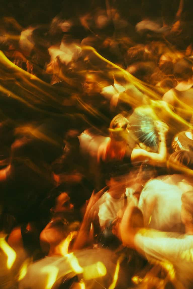 Mensen dansen en genieten van vuurshows op ADE 2025, een energiek nachtfeest.